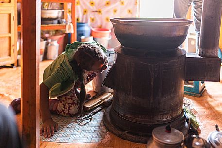 A young girl of a nomadic mongolian family lights the fire for the guests, Mongolia