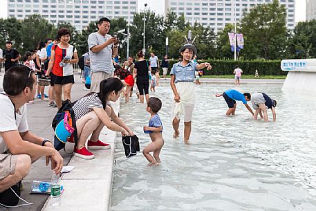 Children playing outside the Beijing National Aquatics Center (called Water Cube) inside the Olympic Green, the olympic park built for 2008 Summer Olympics