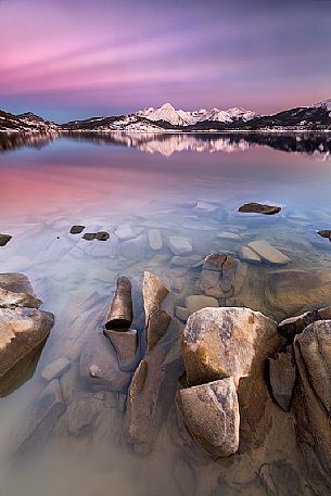 The colors of the sunset light up the lake of Campotosto and the long exposure accentuates the calm and relaxing tones of the nightfall, Gran Sasso and monti della Laga National Park, Abruzzo, Italy
