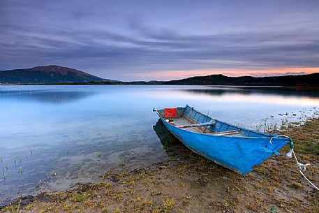 Lonely boat on the shore of Campotosto lake, Gran Sasso and Monti della Laga national park, Abruzzo, Italy