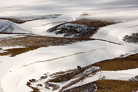 Pattern on the snow along the bank of the Fosso dei Mergani, Pian Grande di Castelluccio di Norcia, Sibillini National park, Umbria, Italy, Europe Pattern on the snow along the bank of the Fosso dei Mergani, Pian Grande di Castelluccio di Norcia, Sibillini National park, Umbria, Italy, Europe