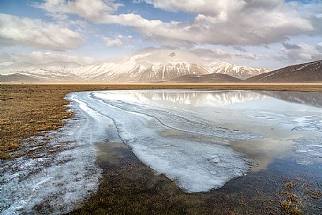 Snow melting in the Pian Grande of Castelluccio di Norcia, in the background the Vettore mountain, Sibillini National Park, Umbria, Italy, Europe