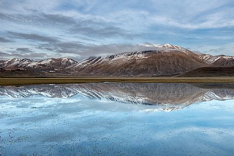 Snow melting in the Pian Grande of Castelluccio di Norcia, in the background the Vettore mountain, Sibillini National Park, Umbria, Italy, Europe