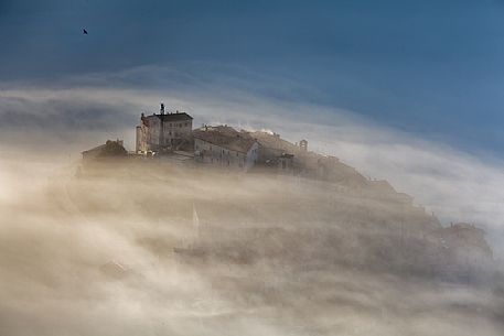 Castelluccio di Norcia village and the Pian Grande in the fog, Sibillini National park, Umbria, Italy, Europe