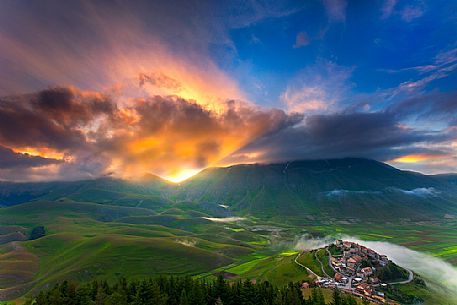 Aerial view of Castelluccio di Norcia and Pian Grande at dawn during the flowering from Monte Veletta, Sibillini National Park, Umbria, Italy, Europe