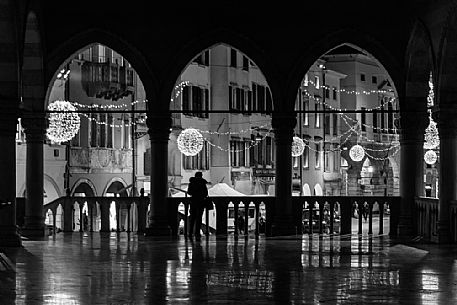 Woman in silhouette in the Loggia del Lionello towards Mercatovecchiohe at Christmas time, Udine, Friuli Venezia Giulia, Italy, Europe