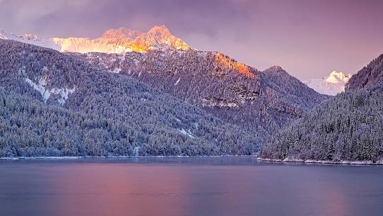 Sauris Lake at dawn after an heavy snowfall