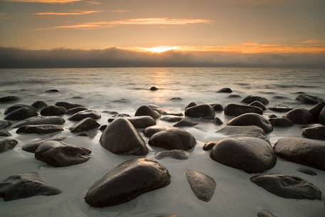 The Sunset on the beach of rounded rocks Utaklein
