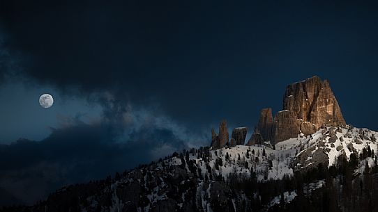 The Cinque Torri of Cortina d'Ampezzo between sunset light and moonrise in a cloudy day, dolomites, Veneto, Italy, Europe