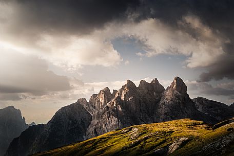 Mount Rudo in the Sesto Dolomites, framed by storm clouds and alpine meadows, South Tyrol, Italy, Europe