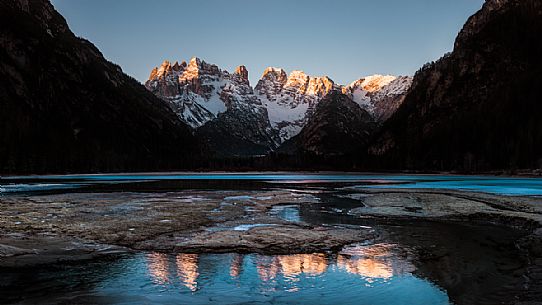 Cristallo mount during sunrise is reflected in the frozen Landro lake, South Tyrol, dolomites, Italy, Europe