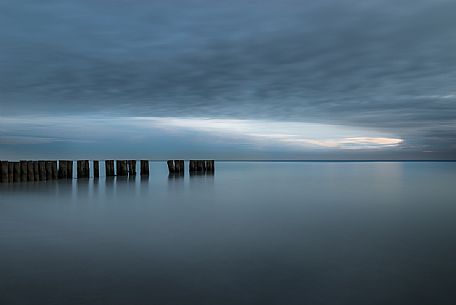 A wooden pile trail points towards the horizon between sky and sea, Bibione, Adriatic sea, Veneto, Italy, Europe