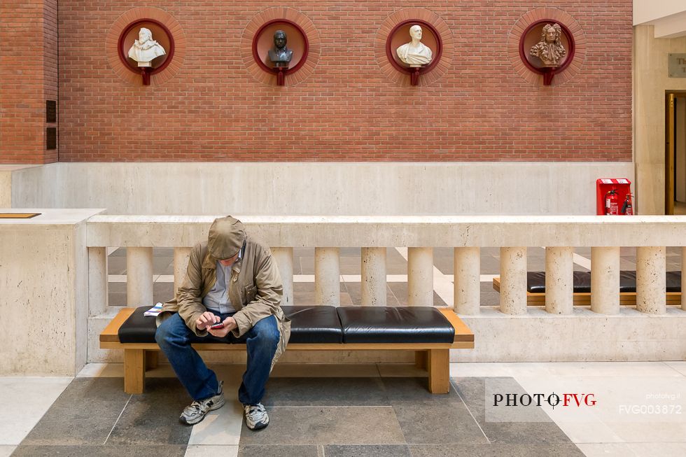 A view inside the British Library. One man look your smartphone.