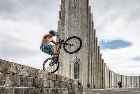 A young trial biker jump on the square in front of the main church of Reykjavk 