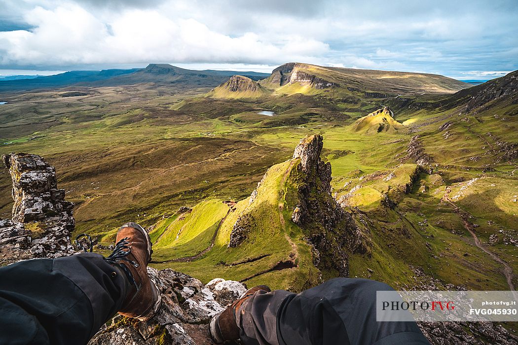 Trekker admires the wild landscape of Quiraing, Trotternish Peninsula in the Isle of Skye, Highands, Scotland, United Kingdom, Europe