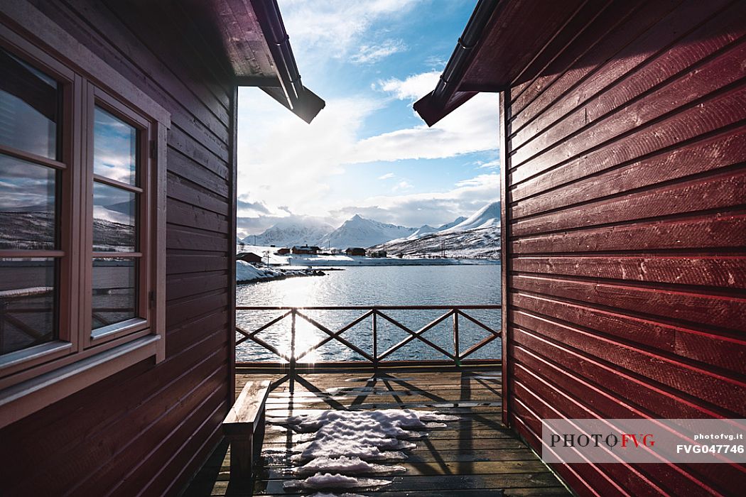 View of the Lyngen Alps in winter time from a typical house of fishermen called rorbu in the village of Nordlenangen, Troms, Norway, Europe
