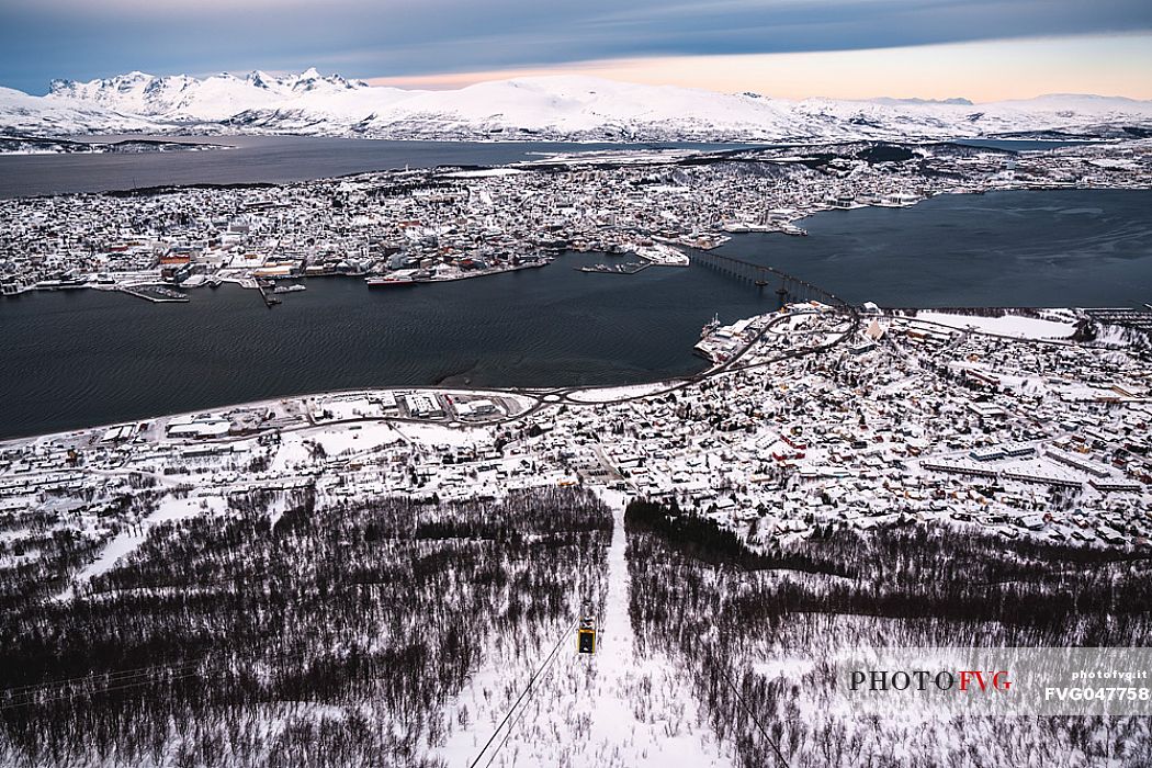 Winter cityscape of Tromso. The panoramic view over the island of Tromsoya can be easily admired from the Storsteinen Mountain thanks to a cable car. From above you can even see the snow-capped mountains on Kvaloya Island in the background, Norway, Europe
