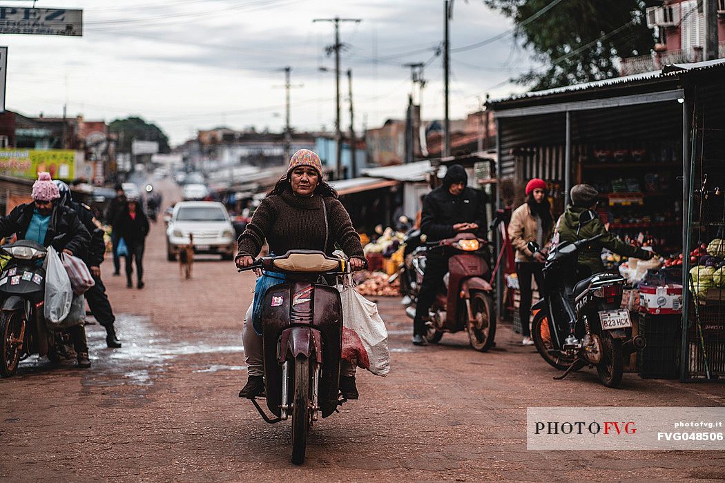 Woman on motorcycle  in the market street of Concepción, Paraguay, America