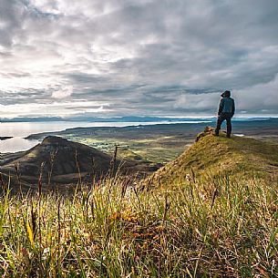 A hiker enjoying the view at lunar landscape of Quiraing on the Trotternish peninsula, Isle of Skye, Scotland, United Kingdom, Europe