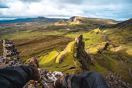 Trekker admires the wild landscape of Quiraing, Trotternish Peninsula in the Isle of Skye, Highands, Scotland, United Kingdom, Europe