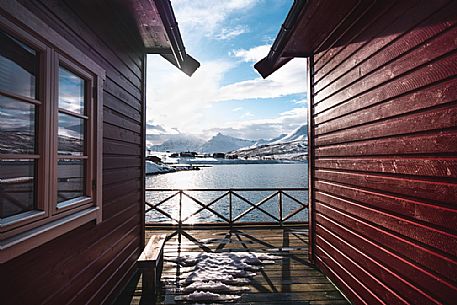 View of the Lyngen Alps in winter time from a typical house of fishermen called rorbu in the village of Nordlenangen, Troms, Norway, Europe
