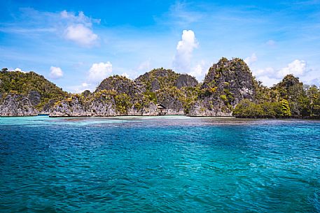 Approaching Piaynemo island, one of the Raja Ampat archipelago most popular tourist spots.
This is one of thousand island located in the northwestern sea of West Papua, one of the most remote province of Indonesia. There are about 1500 thousand island, the largest islands are: Waigeo, Misool, Batanta and Salawati.  The coral reef and the marine biodiversity of Raja Ampat hold the richest variety of species in the world. 
The seascape is enriched by hundreds of small islands with a unique and particular shape. This rock formations despite the arid nature are covered by a rich vegetation. 