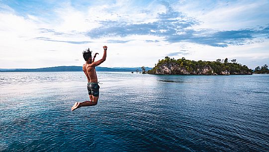 Local man dives in the wonderful sea of the Kri island, one of the Raja Ampat archipelago most popular tourist spots, West Papua, Indonesia