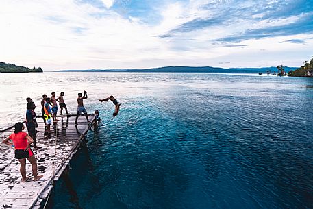 Group of people dives in the wonderful sea of the Kri island, one of the Raja Ampat archipelago most popular tourist spots, West Papua, Indonesia