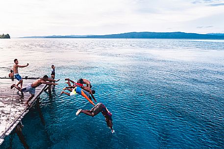 Group of people dives in the wonderful sea of the Kri island, one of the Raja Ampat archipelago most popular tourist spots, West Papua, Indonesia