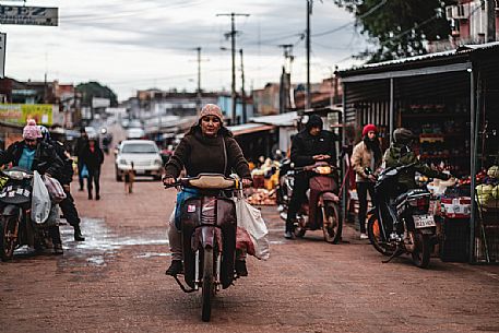 Woman on motorcycle  in the market street of Concepción, Paraguay, America