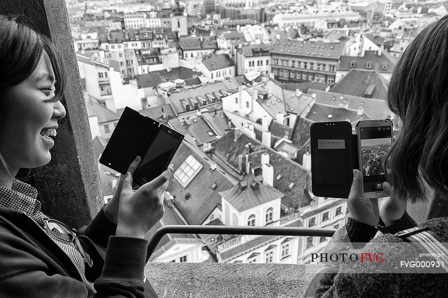 Asiatic girls tacking pictures with mobile phones from the City Hall Tower, Staroméstské radnice Asiatic girls tacking pictures with mobile phones from the City Hall Tower, Staroméstské radnice