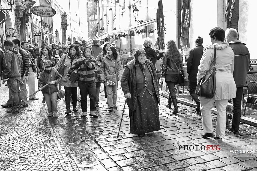 Old woman traditionally dressed, walking on a Street of Staré Mesto Old woman traditionally dressed, walking on a Street of Staré Mesto