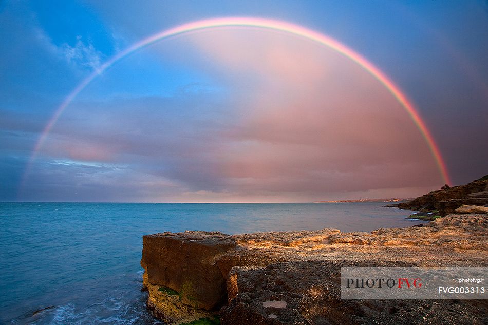 A huge rainbow over the sea at sunset