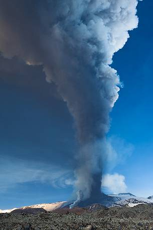 Etna,4th paroxysm of 2012,a huge cloud of ash rises into the sky while below a pyroclastic cloud invades the snowfields