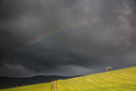 Light rainbow over rain clouds
