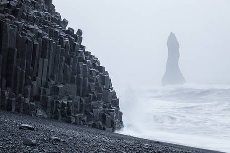 Basalt columns on the Vik's beach and cliffs wrapped in mist