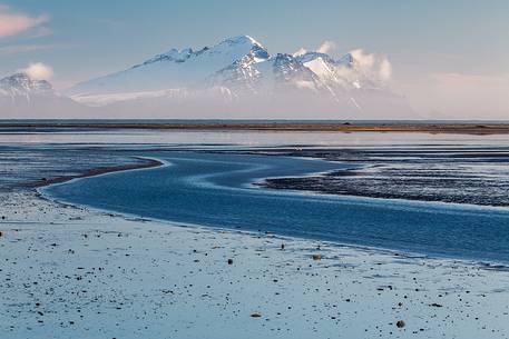 Saltwater lagoon along the coast of Iceland and mountains in the background.