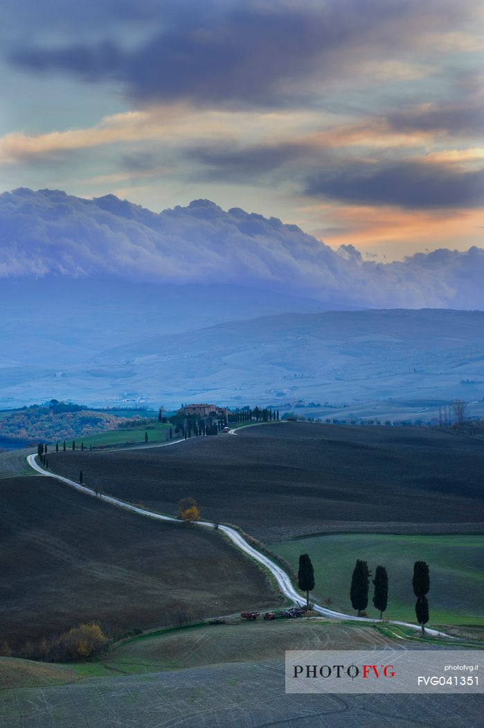 Dirt road and farm in the Val d'Orcia or Orcia valley at twilight, Tuscany, Italy, Europe