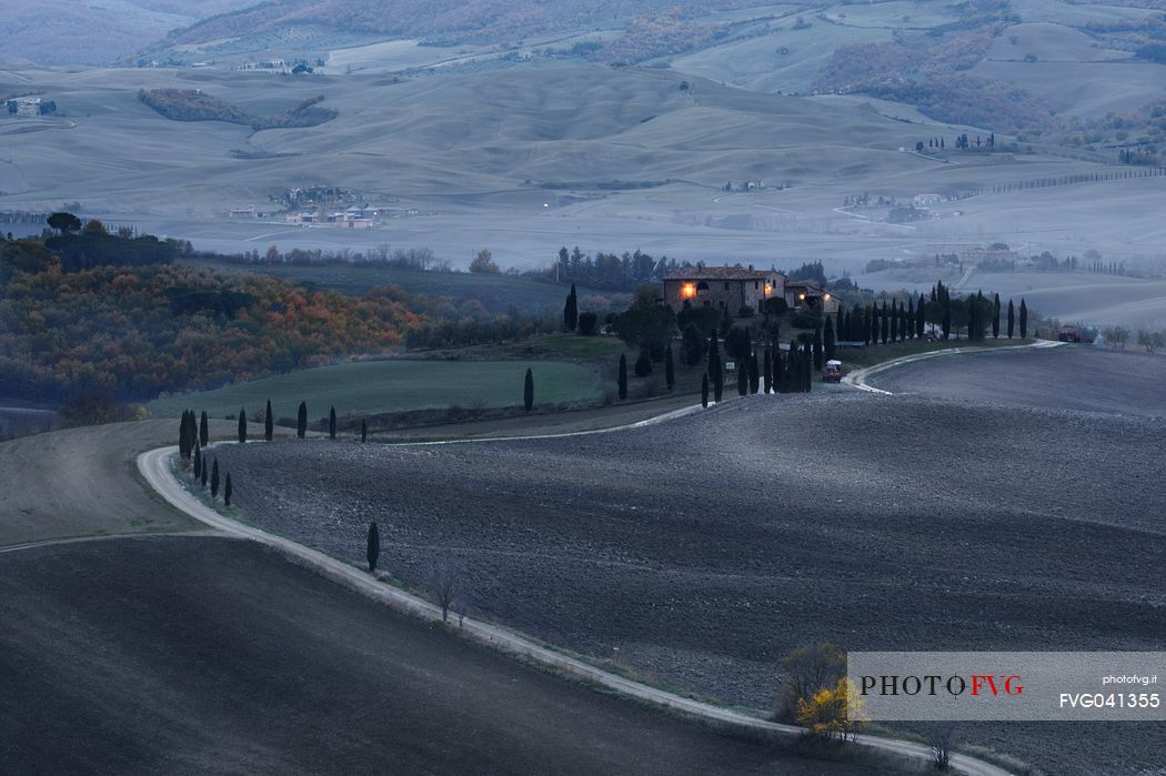Dirt road and farm in the Val d'Orcia or Orcia valley at twilight, Tuscany, Italy, Europe