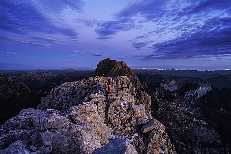 Hikers at the first light of the day from the top of the Foronon del Buinz near the Luca Vuerich hut, Montasio mount, Julian alps, Friuli Venezia Giulia, Italy, Europe