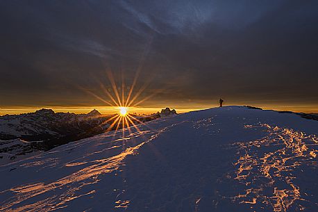 Hiker on the top of Lagazuoi mountain at dawn, in the background Sorapiss, Antelao and  Pelmo, dolomites, Cortina d'Ampezzo, Veneto, Italy, Europe
