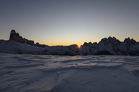 The sun rises behind Le Ciampedele, between the western side of the Tre Cime di Lavaredo and the Cadini di Misurina, on a frosty december morning, dolomites, South Tyrol, Italy, Europe