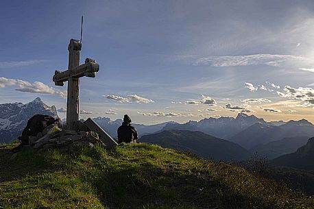 Hiker waits for the sunset from the top of Col de la Puina admiring the Marmolada, on the left the Civetta mount, dolomites, Veneto, Italy, Europe