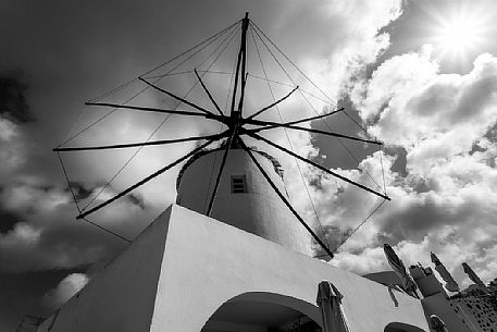 Windmill on top of Oia village in Santorini island, Greece. Black & white shot