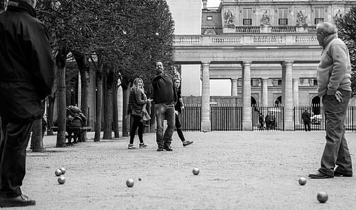 People playing the french game petanque (Bowls games) into the Palais Royale gardens, Paris, France