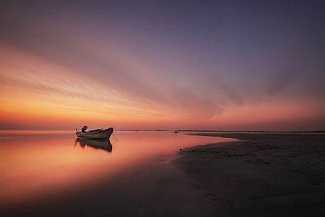Boat in the red sunset, Grado lagoon, Italy