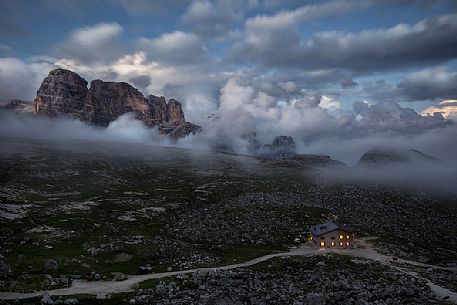 Lavaredo hut wrapped by clouds at dusk, Tre Cime natural park, dolomites, Italy