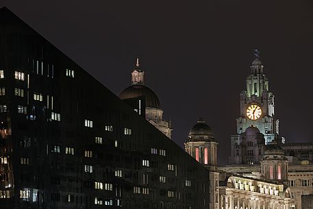 Cityscape from Albert docks at night, in the background the  Three Graces and the Royal Liver Building,  Liverpool, United kingdom