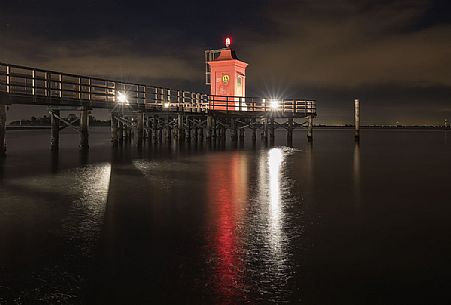 Night view of lighthouse and pier in Punta Faro, Lignano Sabbiadoro, Friuli Venezia Giulia, Italy