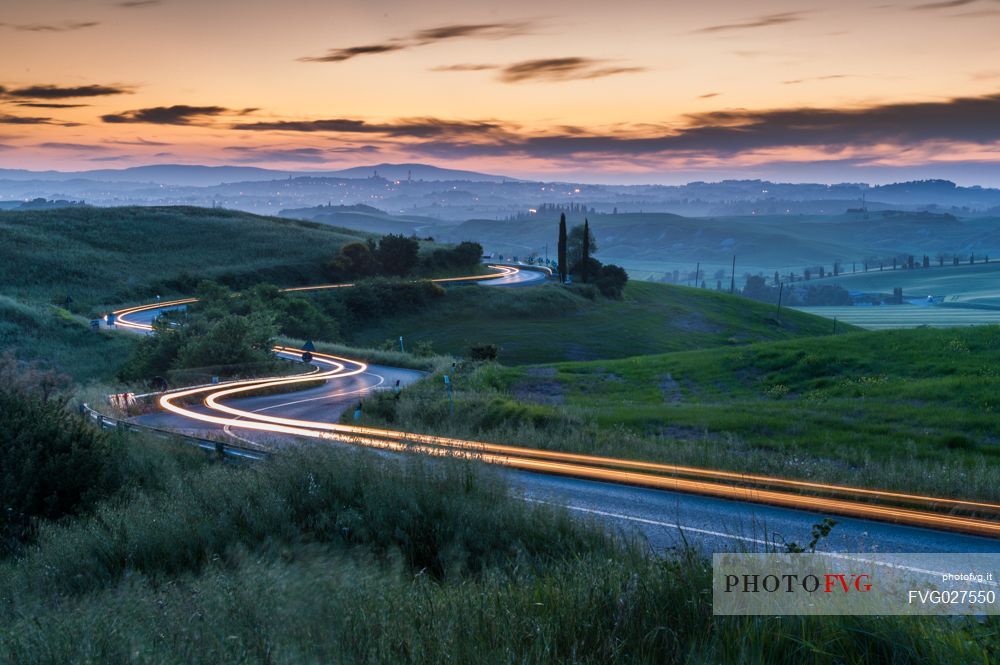 Crete Senesi landscapes, red car light trails on a road, Orcia valley, Tuscany, Italy